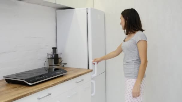 Junge Frau holt Lebensmittel aus dem Kühlschrank — Stockvideo