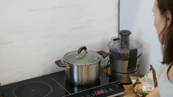 Woman hand starts the induction cooker — Stock Video