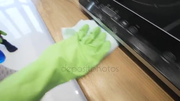 Женщина убирает свою кухню в зеленых перчатках — стоковое видео