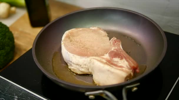 Pyszny stek umieszczone na gorącym grillu doprawione solą i pieprzem. Smażyć steki surowego mięsa wołowego. mięso jest smażone masło i podgrzewany na patelni. zbliżenie. zwolnionym tempie — Wideo stockowe