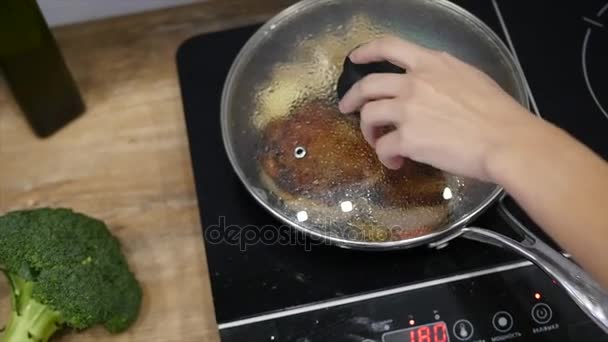 Deliziosa bistecca posta sulla griglia calda guarnita con sale e pepe. Carne cruda di manzo fritta. carne essendo burro fritto e scaldandosi in una pentola. primo piano. rallentatore — Video Stock