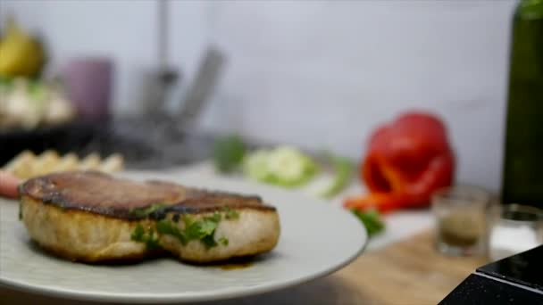 Жінка кладе м'ясний стейк і овочі на тарілку — стокове відео