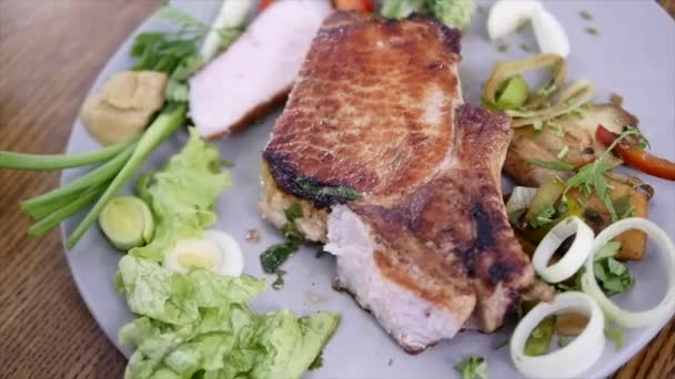 Frisch gegrilltes Rindfleischsteak auf Teller über Holztisch — Stockvideo