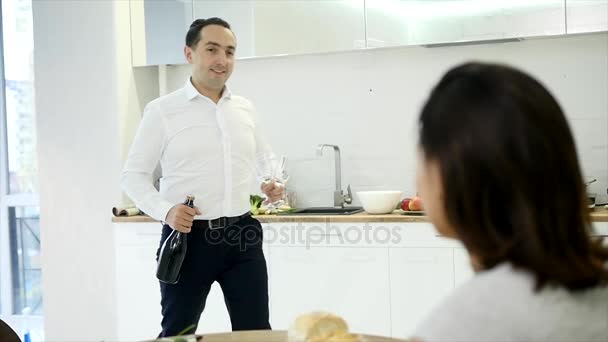 Mann schenkt zwei Gläser Champagner ein, um Einzug mit Freundin zu feiern — Stockvideo