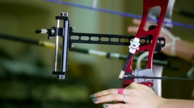 Ok ve yay tutan genç kişi elinde, eğitmen çekim yöntemi açıklar.