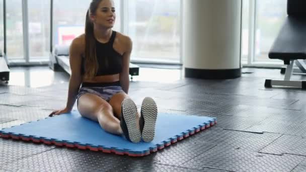 Ung kvinde gør øvelserne i gymnastiksalen – Stock-video