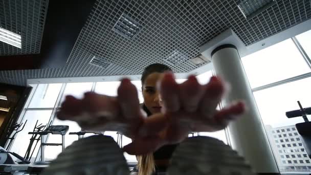 Mujer joven haciendo ejercicio de estiramiento en el gimnasio — Vídeos de Stock