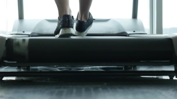 Detailní záběr Zenske nohy na běžícím pásu v posilovně — Stock video