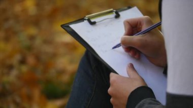 yakışıklı adam pen tarafından bir şey bir kağıt parçası üzerinde yazıyor