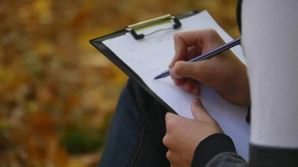 Handsome man writes something by pen on a piece of paper — Stock Photo, Image