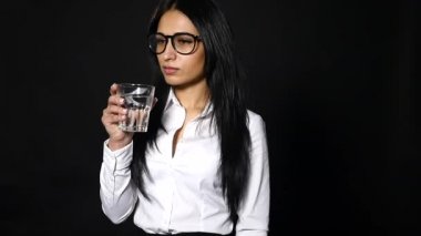 siyah arka plan üzerine bir bardak su tutan genç güzel kız