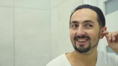 Genç erkek temizlik kulak bir pamuk bez ile yakın Up-Shot