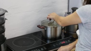 Kadın eli düdüklü tencereyi çalıştırıyor.