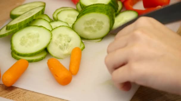 直接以上的妇女切割胡萝卜在木板上拍摄。封锁头顶的新鲜蔬菜在柜台上。女性正在厨房里准备食物 — 图库视频影像