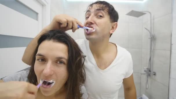 Pareja cepillarse los dientes en el baño — Vídeos de Stock