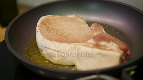 Deliziosa bistecca posta sulla griglia calda guarnita con sale e pepe. Carne cruda di manzo fritta. carne essendo burro fritto e scaldandosi in una pentola. primo piano. rallentatore — Video Stock