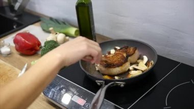 Tuz ve biber ile süslenmiş sıcak ızgarada lezzetli biftek yer. Biftek çiğ et Biftek kızart. et olmak tereyağı ve bir tavada ısıtmalı kızarmış. portre. ağır çekim