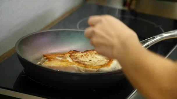 Pyszny stek umieszczone na gorącym grillu doprawione solą i pieprzem. Smażyć steki surowego mięsa wołowego. mięso jest smażone masło i podgrzewany na patelni. zbliżenie. zwolnionym tempie — Wideo stockowe