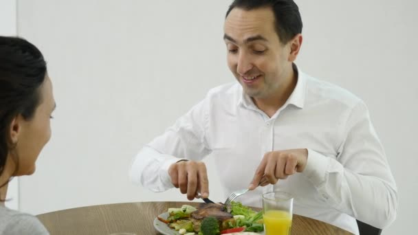 Pareja feliz charlando y desayunando juntos en casa en la cocina — Vídeo de stock