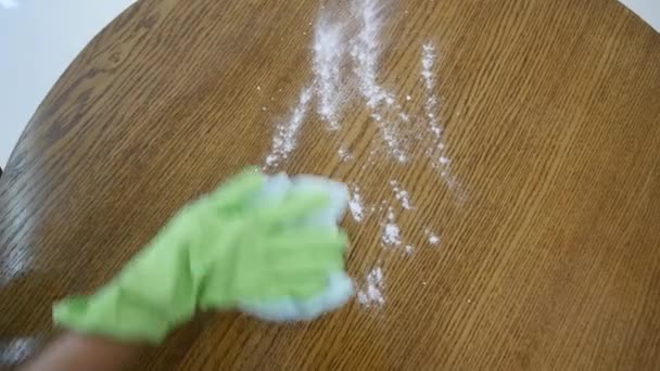 Une femme dans un T-shirt gris serré avec un décolleté profond essuie une grande table de cuisine avec un chiffon — Video