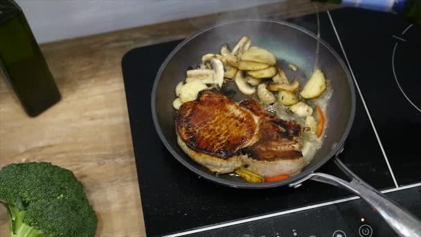 Bife delicioso colocado na grelha quente decorado com sal e pimenta. Bife frito carne crua. a carne que frita a manteiga e aquece-se em uma panela. Fechar. câmara lenta — Vídeo de Stock