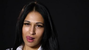 Dudaklarını yalayarak genç seksi bir kadın. koyu arka plan üzerinde