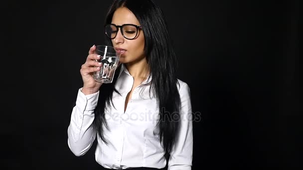 Mujer de negocios sosteniendo vaso de agua y bebida, aislada sobre fondo negro — Vídeos de Stock