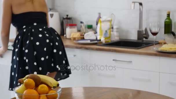 Щаслива молода жінка робить домашню роботу. Мила домогосподарка прибирає кухню — стокове відео
