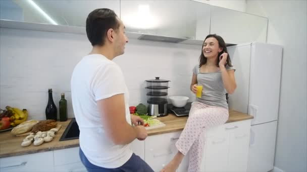 Casal feliz a cozinhar juntos na cozinha. câmara lenta — Vídeo de Stock