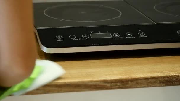 Frau räumt ihre Küche mit grünen Handschuhen auf — Stockvideo