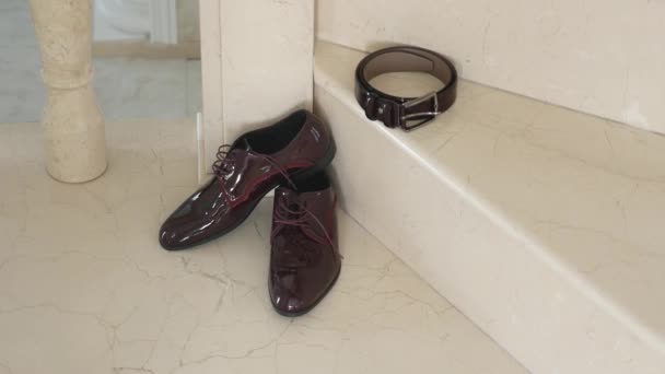 Zapatos de hombre en el piso primer plano de color marrón. Caro brillante cuero pulido zapatos masculinos de pie en el fondo del piso — Vídeos de Stock