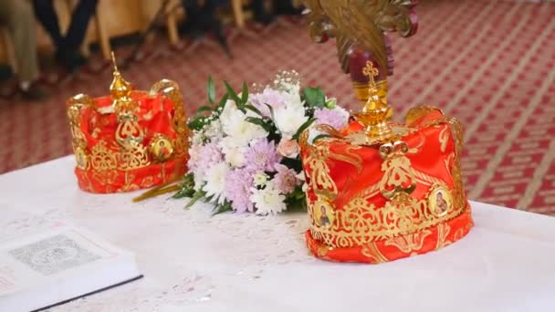 Atributos da igreja para cerimônia de casamento. Coroas de ouro estão no altar. Atributos do padre. Interior da igreja — Vídeo de Stock