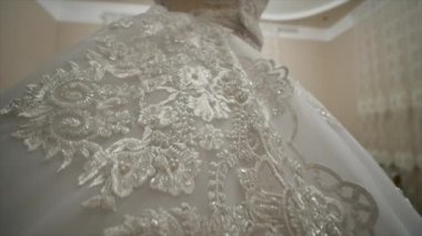 Odadaki bir mankenin üzerindeki beyaz gelinlik.
