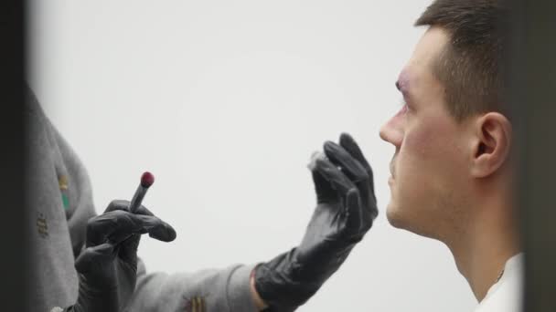 Візажист на роботі, застосовуючи макіяж спеціальних ефектів — стокове відео