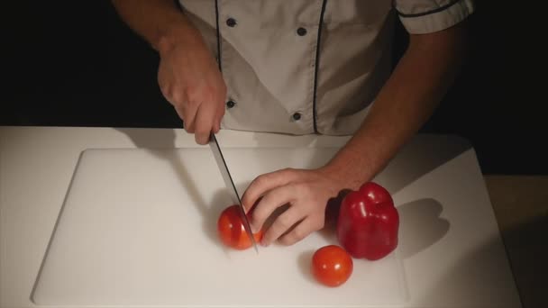 Szef kuchni krojenia na kawałki pomidora z nożem. zwolnionym tempie — Wideo stockowe