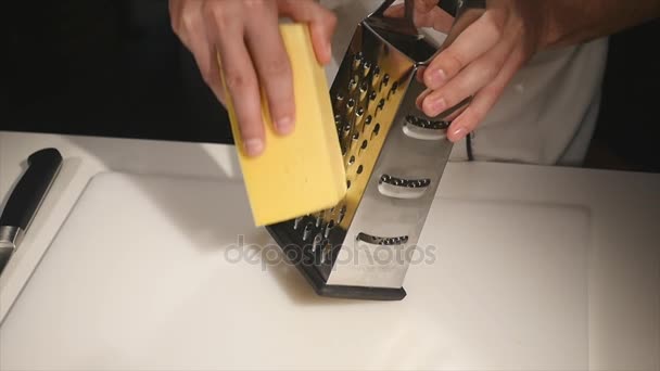 The cook rubs cheese on a grater — Stock Video