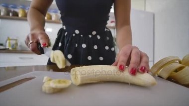 Kadın ev bir mutfak bir ahşap mutfak tahtada bir muz dilimleri. Evde yemek yemek. Mutfakta ev atmosfer