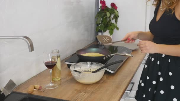 Μαγειρική τις τηγανίτες στο τηγάνι. Μαγειρική τις τηγανίτες σε ένα τηγάνι. Η γυναίκα αναστρέφει την τηγανίτα στο τηγάνι. Μαγειρικές τέχνες. Μαγείρεμα — Αρχείο Βίντεο