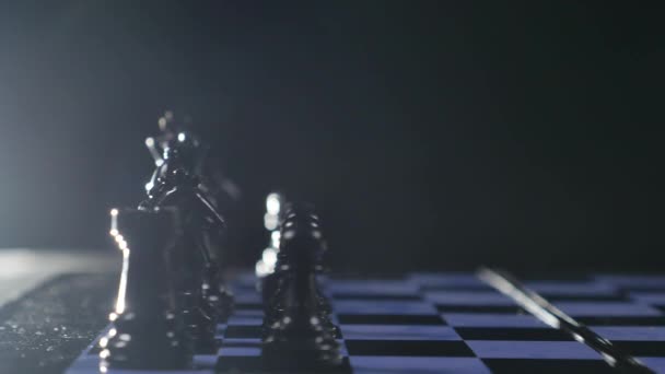 Jogo de tabuleiros de xadrez e peças de xadrez sobre fundo preto — Vídeo de Stock