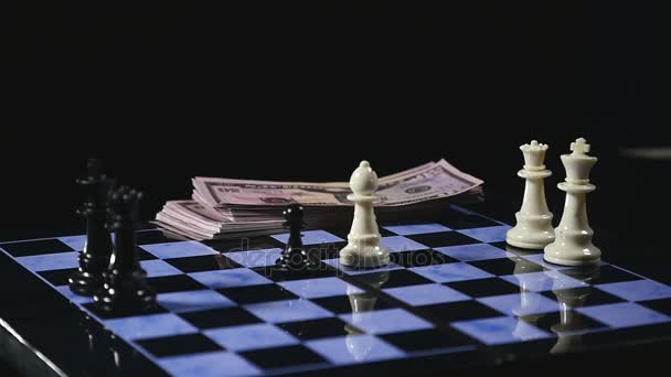 Tableros de ajedrez y piezas de ajedrez juegan sobre fondo negro. juego por dinero — Vídeo de stock
