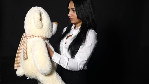 Молода жінка кидає плюшевого ведмедя - ізольовані на чорному — стокове відео