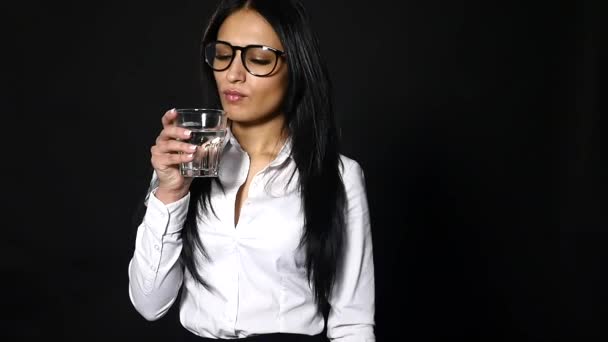 Femme d'affaires tenant un verre d'eau et de boisson, isolée sur fond noir — Video