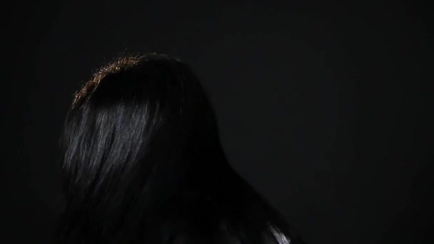 Mujer fijando su cabello sobre fondo negro — Vídeos de Stock