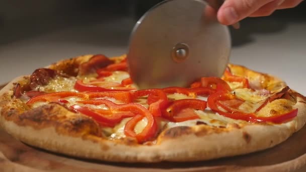 Tagliare la pizza su un tagliere di legno — Video Stock