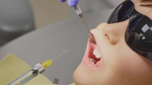 Dentista hace inyección anestésica a un niño pequeño — Vídeos de Stock