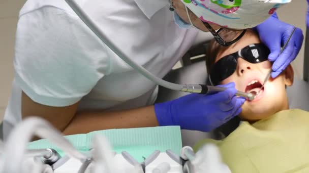 Gros plan petit enfant pendant la procédure de perçage des dents traitement au cabinet de la clinique dentaire — Video