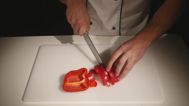 Kocken skivor röd paprika — Stockvideo