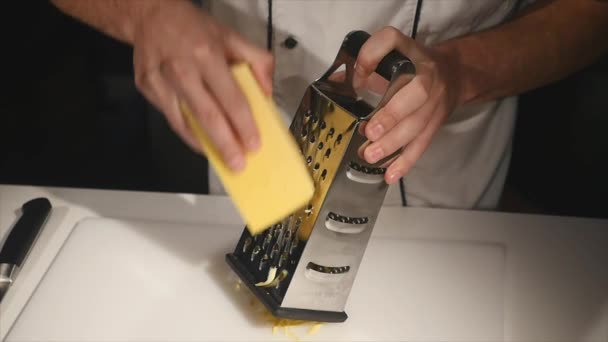 Повар втирает сыр в терку — стоковое видео