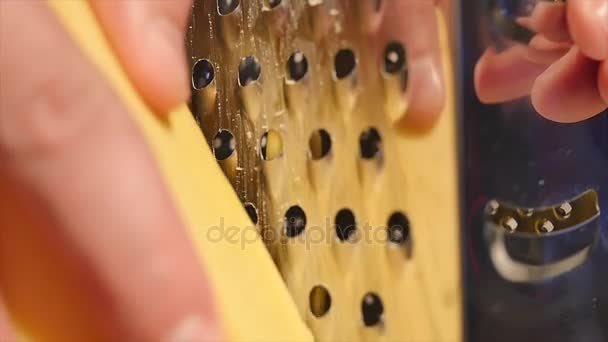 El cocinero frota el queso en un rallador — Vídeo de stock