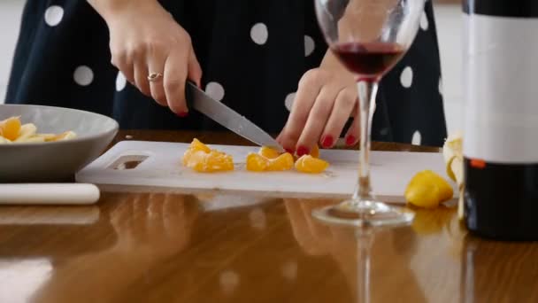 Mujer limpia mandarina en la cocina — Vídeos de Stock